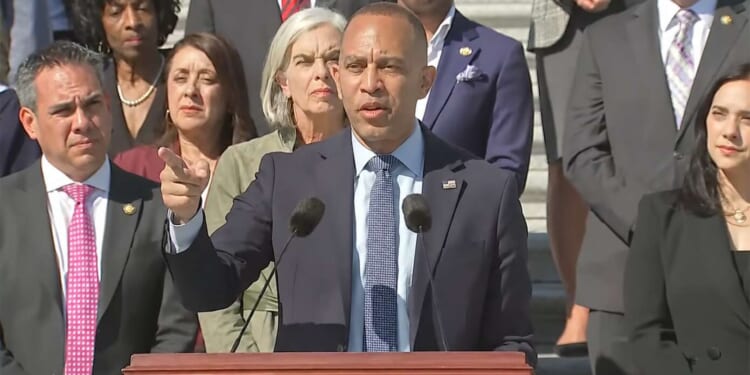 House Minority Leader Hakeem Jeffries giving a speech in front of Democratic members of Congress.